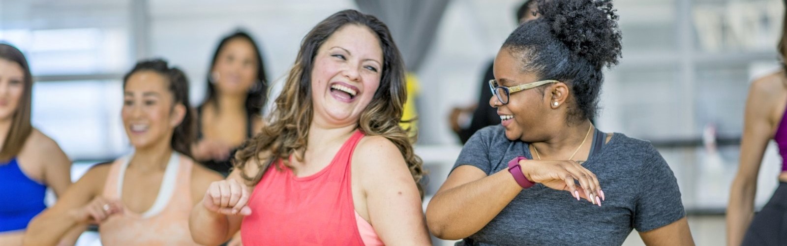 Group of smiling women dancing in zumba class 